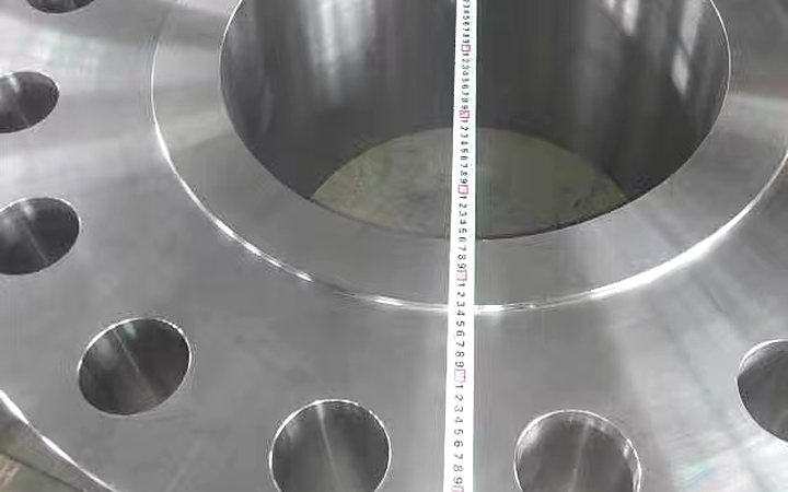 Close view of drilled bolt holes on a nickel alloy flange machined for high pressure service